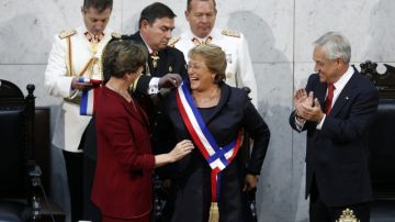 Michelle Bachelet (c), tras ser investida en su cargo por la nueva presidenta del Senado, Isabel Allende (i), junto al expresidente  Sebastián Piñera (d).