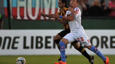 Emiliano Albin, de Peñarol, disputa el balón con Ramiro Carrera, de Arsenal (der.), durante el encuentro de Copa Libertadores.