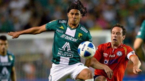 El delantero del León, Carlos Peña y el mediocampita de Cruz Azul, Gerardo Torrado, disputan el esférico