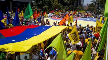 Manifestantes opositores al Gobierno del presidente Nicolás Maduro participan en una concentración en El Rosal.