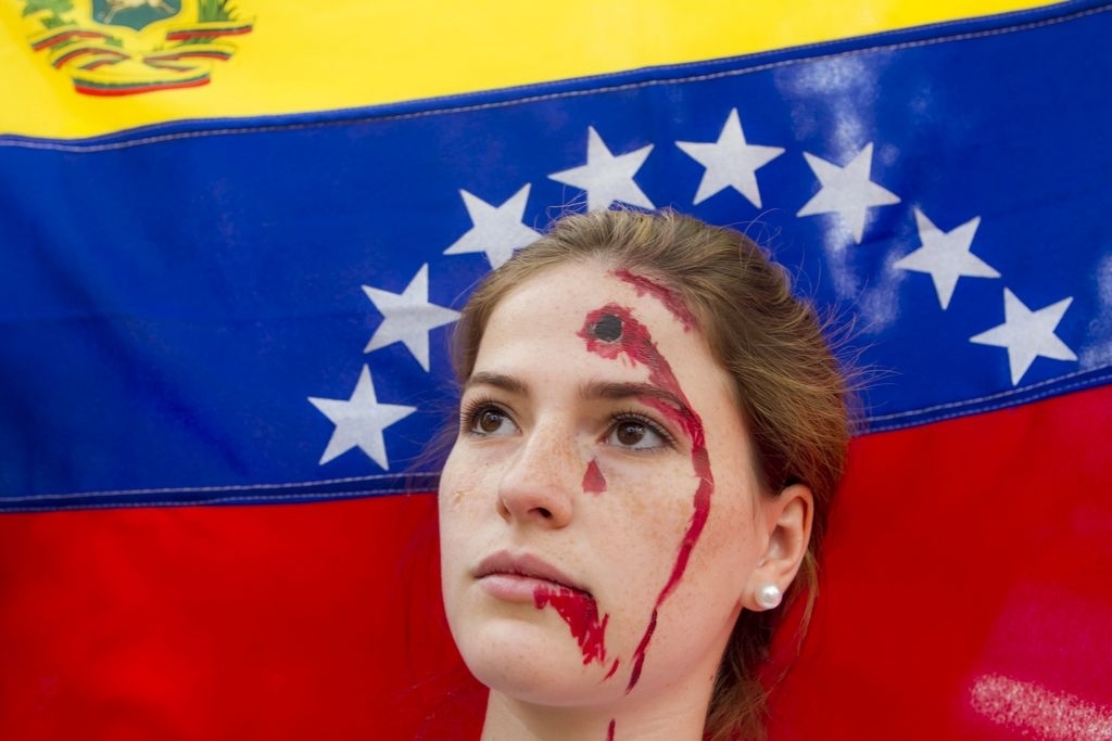 Una manifestante opositora al Gobierno del presidente Nicolás Maduro participa en una protesta con maquillaje de una supuesta herida en su frente.