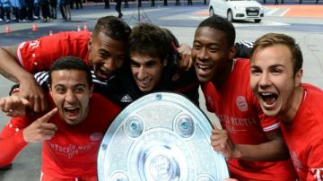 Los jugadores del Bayern Munich Thiago, Jerome Boateng, Javier Martínez, David Alaba y Mario Goetze celebran con una imitación del escudo del campeonato