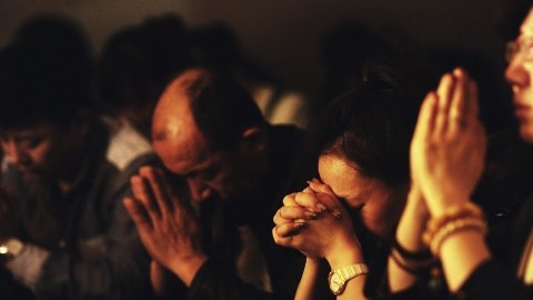 Familiares de los pasajeros del vuelo MH370 de Malaysian Airlines desaparecido el pasado 8 de marzo ofrecen oraciones por sus parientes, en Pekín, China.