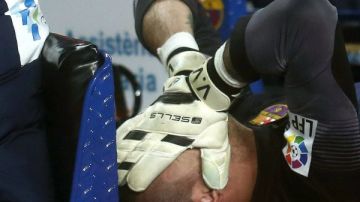 El portero del FC Barcelona Víctor Valdés es retirado en camilla tras sufrir una lesión