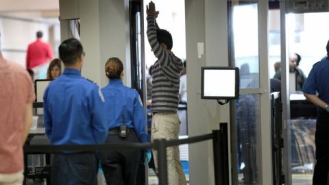 Agentes del TSA registran a un pasajero en un punto de seguridad en el aeropuerto de Los Ángeles.