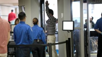 Agentes del TSA registran a un pasajero en un punto de seguridad en el aeropuerto de Los Ángeles.