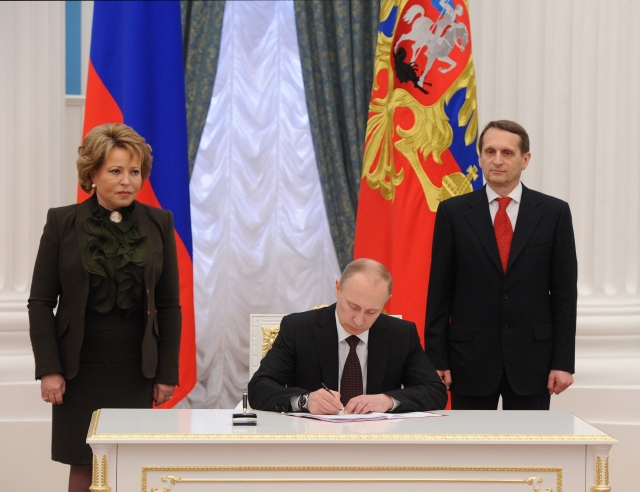 Putin firmando la ley sobre la unión de Crimea y Sebastopol con Rusia.