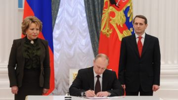 Putin firmando la ley sobre la unión de Crimea y Sebastopol con Rusia.