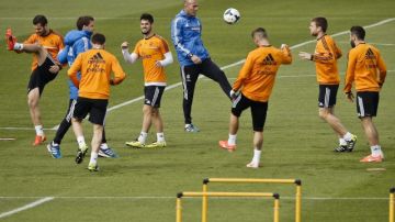 Jugadores del Real Madrid, junto al técnico asistente,  Zinedine Zidane (centro), en la práctica.