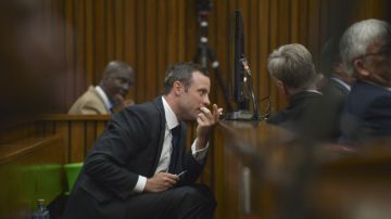El atleta paralímpico sudafricano Óscar Pistorius (izq.) conversa con uno de sus abogados .