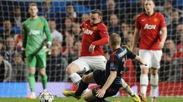 Bastian Schweinsteiger,  del Bayern, se barre  ante el delantero del Man-Utd,  Wayne Rooney, en el juego de ayer.