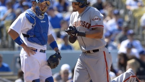 EJ Ellis, catcher de Dodgers mira con desconsuelo a Michael Morse cruzar por home después de batear jonrón.