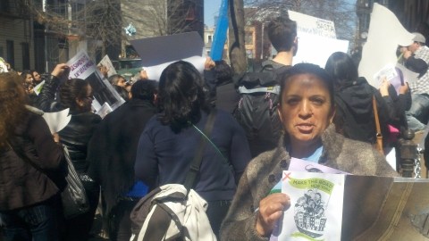 Raquel Navas sostiene un cartel que muestra las malas condiciones en que está su apartamento en el 98 de la calle Linden.