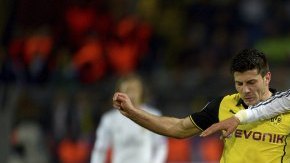 El lateral izquierdo portugués del Real Madrid Fabio Coentrao (c) lucha por el balón con el jugador del Borussia Dortmund Milos Jojic (i)