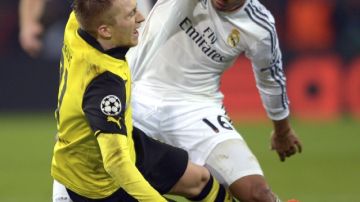 El mediocampista del Real Madrid,  Carlos Henrique Casemiro (der.),  pelea por el balón con Marco Reus  del Borussia Dortmund.