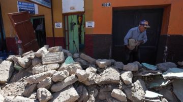 Un hombre retira escombros de una vivienda en Arica  tras el terremoto  que sacudió  las regiones de Arica y Parinacota, Tarapacá y Antofagasta, en el norte del país.