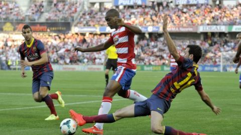 El defensor francés Foulquier (c), del Granada, trata de escapar de la marca de Sergio Busquets (d) del  Barcelona.