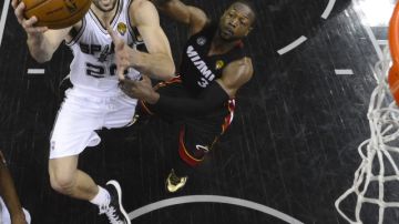 El argentino Manu Ginóbili (izq), de los Spurs, trata de encestar ante la mirada de Dwyane Wade (d), del Heat, en las finales de 2013.