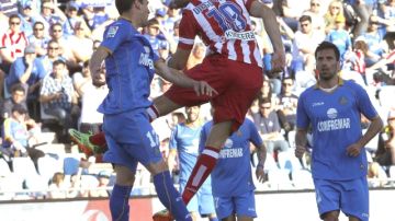 El delantero del Atlético de Madrid Diego Costa (centro) cabecea la pelota  durante el encuentro ante el Getafe, ayer.