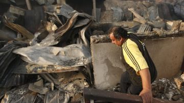 Un hombre trata de acceder a su casa  después de un incendio en la ciudad de Valparaíso (Chile).