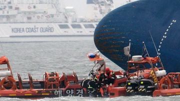 Oficiales de la guardia costera surcoreana recuperan el cuerpo de una de las víctimas tras el naufragio del ferri Sewol en Corea del Sur.