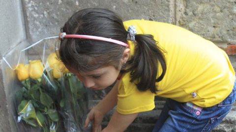 Una niña deposita un ramo de flores en uno de los muros de la casa del fallecido escritor colombiano Gabriel García Márquez, en Ciudad de México.