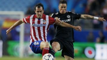 El defensa uruguayo del Atlético de Madrid Diego Godín (i) pelea un balón con el delantero español del Chelsea, Fernando Torres