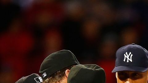 El umpire de home Gerry Davis checa la sustancia en el cuello de Michael Pineda de los Yankees durante el segundo inning en Fenway Park.