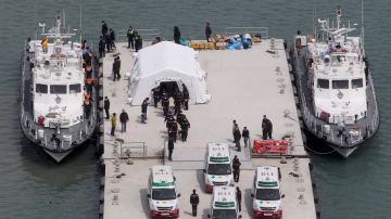 Miembros de los servicios de rescate trasladan los cuerpos de víctimas del naufragio del Sewol en Jindo.