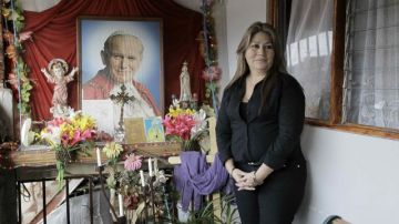 Floribeth Mora posa para la prensa el 5 de julio de 2013, junto a un altar que tiene de Juan Pablo II en su casa de habitación en Dulce Nombre de Tres Ríos, en la provincia de Cartago (Costa Rica).