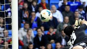 El defensa del Real Madrid Sergio Ramos (d) remata ante Andrés Fernández, portero de Osasuna.