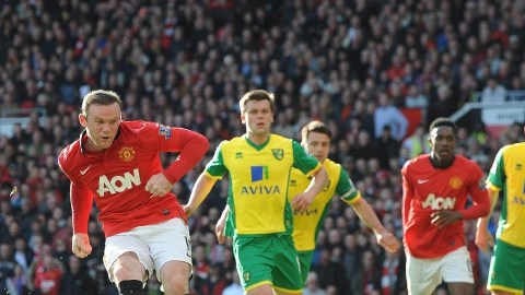 Wayne Rooney (izq.) anota de pena máxima el primer gol de los 'Diablos Rojos' ante Norwich City.