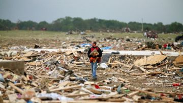 Mark Wade camina sobre los escombros de viviendas destruidas  por los tornados en Vilonia, Arkansas.