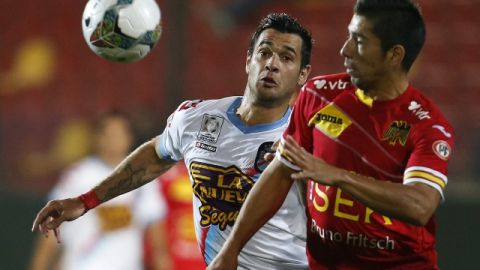El jugador de Unión Española Jorge Ampuero (der) y Milton Caraglio  de Arsenal disputan un balón en el partido de ayer.