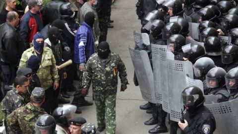 Separatistas prorrusos (i) hacen frente a policías antidisturbios ucranianos (d) en el exterior del edificio la Administración Regional de Lugansk, Ucrania.