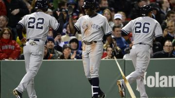 El jardinero central de los Yankees, Jacoby Ellsbury (i) es felicitado por su compañero Alfonso Soriano (c) después de anotar en Boston el 24 de abril pasado.