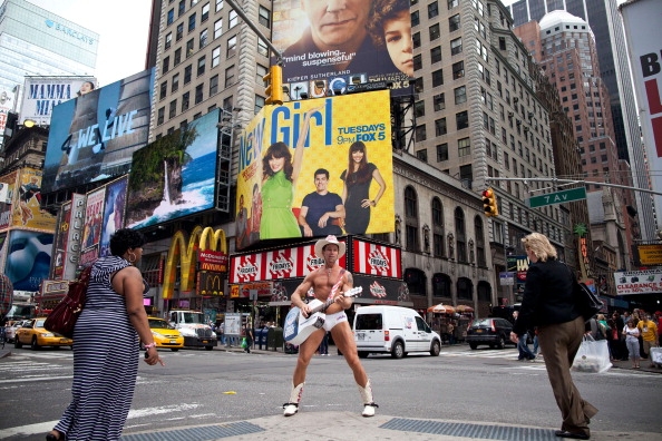 "Naked Cowboy" se desplaza por Times Square, en Manhattan, cubierto sólo con calconzillos, botas vaqueras y  una guitarra.