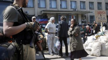 Un partidario pro-ruso sostiene una pistola en frente de un edificio de la administración local en Kramatorsk, Ucrania.