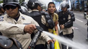 Miembros de la Policía Nacional Bolivariana (GNB) dispersan un grupo de manifestantes opositores al Gobierno  en Caracas.