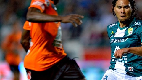 Walter Ayoví  (izq.) y Carlos Peña son vistos en acción durante el juego que tuvieron el 25 de enero en el Estadio Nou Camp.