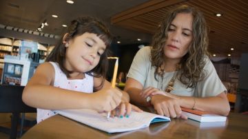 Roxana A. Soto (d.), co-autora del libro "Bilingual is Better", enseña a su hija Vanessa, de 6 años de edad, cómo escribir en español.