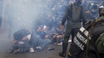 Manifestantes detenidos por la Guardia Nacional Bolivariana (GNB) durante una marcha en Caracas.