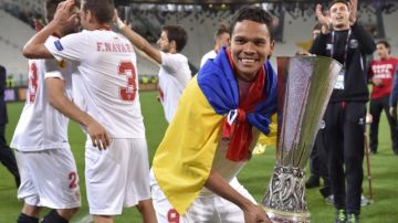 El goleador colombiano Carlos Bacca levanta el trofeo de campeón de la Liga Europa, ganado ayer con el Sevilla ante Benfica.