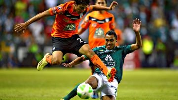 Rodolfo Pizarro, del Pachuca, pierde el balón ante la barrida del jugador del León,    Edwin Hernández, durante el partido en el Nou Camp.