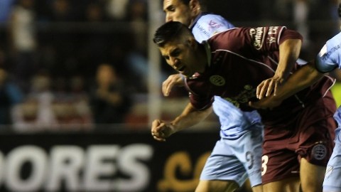 El jugador de Lanús, Óscar Benítez (izq), recibe una falta  de  Luis Gutiérrez (der.), del Bolívar, durante el juego de ayer.