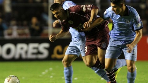 El jugador de Lanús, Óscar Benítez (izq), recibe una falta de Luis Gutiérrez (der.), del Bolívar, durante el juego de ayer.