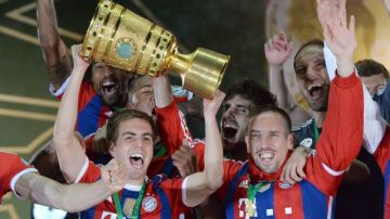 Philipp Lahm (izq.) y Franck Ribery celebran felices el título de la Copa Alemana, ayer.