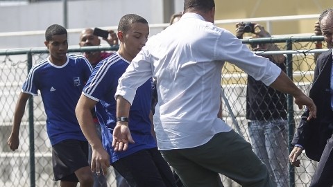 Ronaldo Nazário toca la pelota junto al  ministro brasileño de Deportes, Aldo Rebelo,  y jóvenes de una favela en Río de Janeiro.