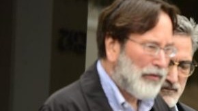 Familiares de la víctima del tiroteo masivo Christopher Martinez (d) ven a su padre, Richard Martínez (i), expresar su rabia y tristeza cuando habla a los medios de comunicación en Goleta, California.