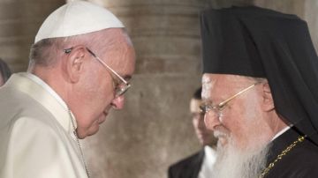 El Papa Francisco y el Patriarca Bartolomé de Constantinopla hablan al final de una ceremonia religiosa en una iglesia.
